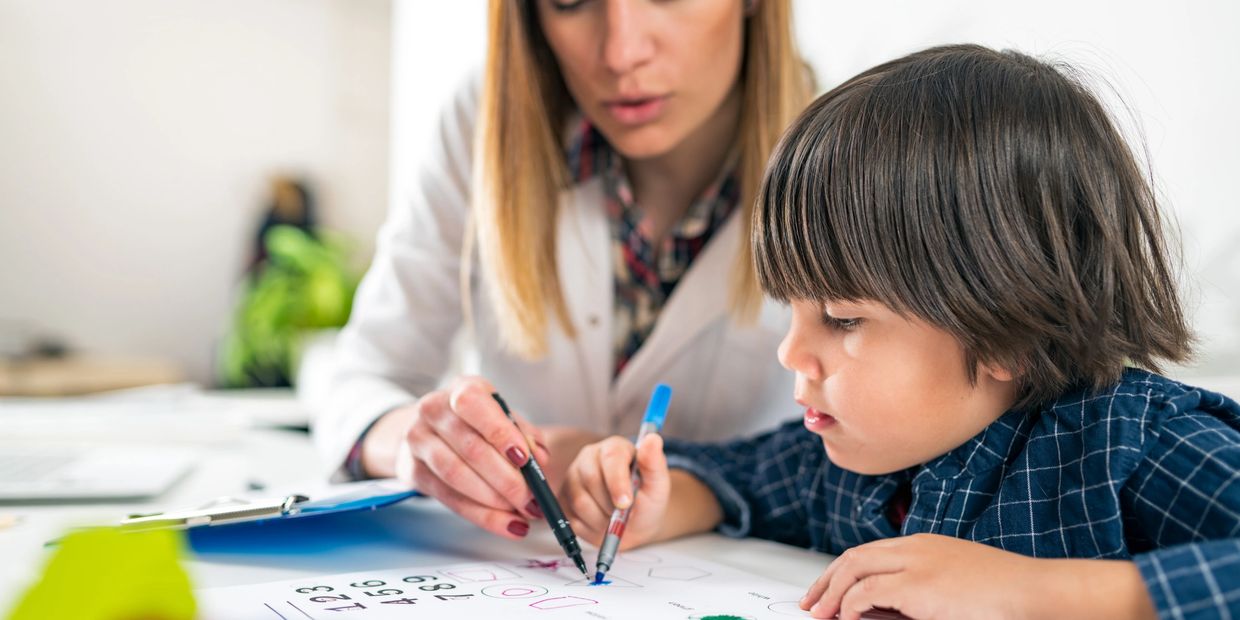 School-based occupational therapist works with boy on handwriting skills and motor coordination