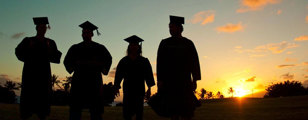 Silhouettes of graduates at sunset.