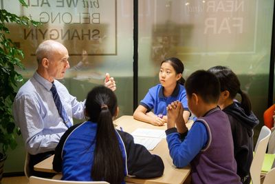 Teacher engaging with students in a classroom discussion.