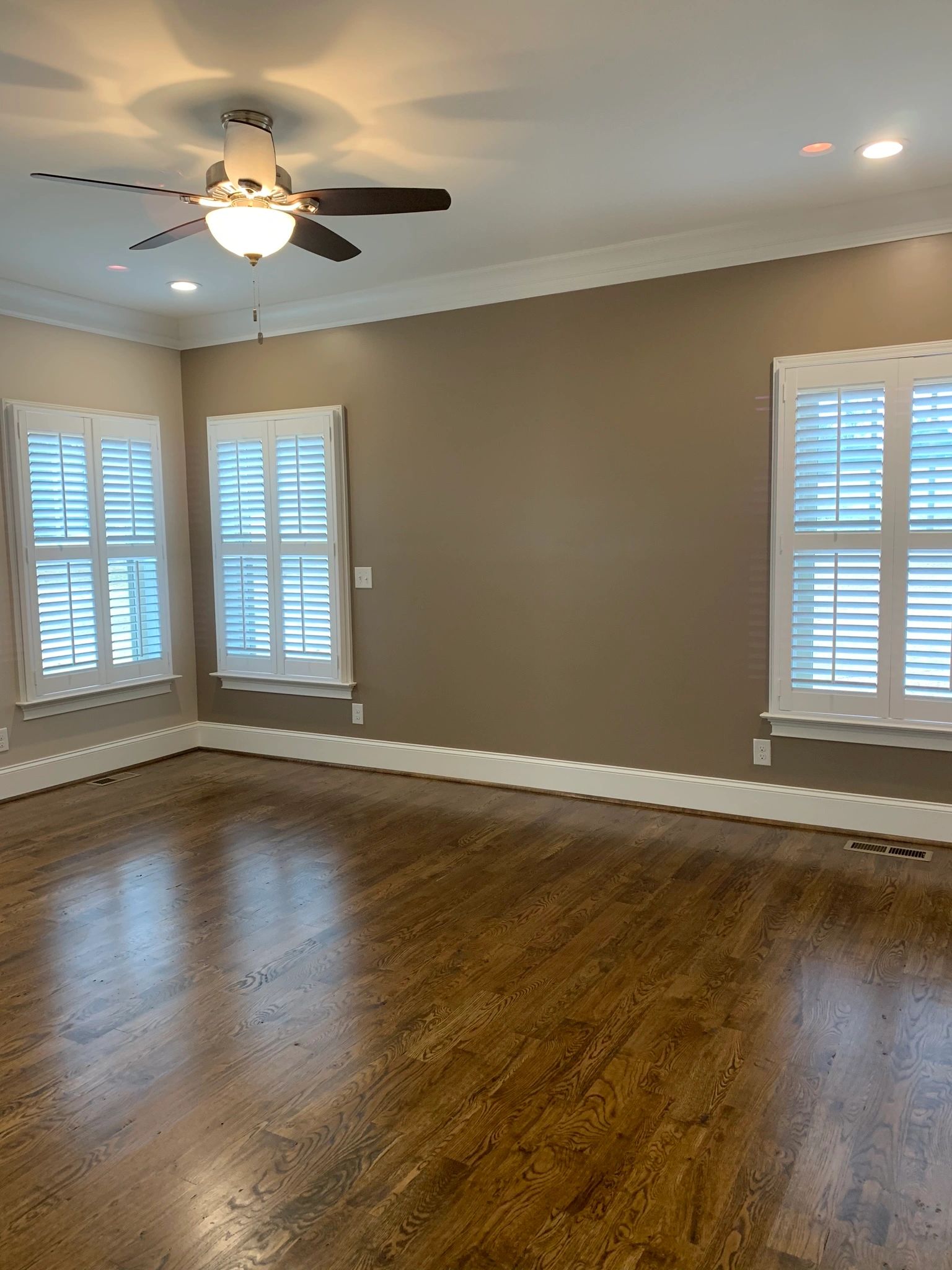 Sand on site hardwood floors. Ceiling fan with light and shutters on windows