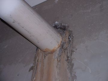Picture of water coming around a pipe line that goes through a cement foundation wall.