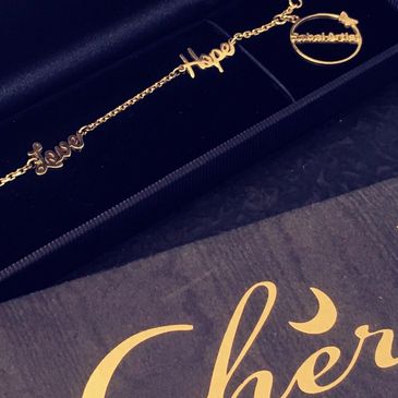 The Cherubine brand features a 18 carat gold bracelet with the words faith, love and hope in a box 