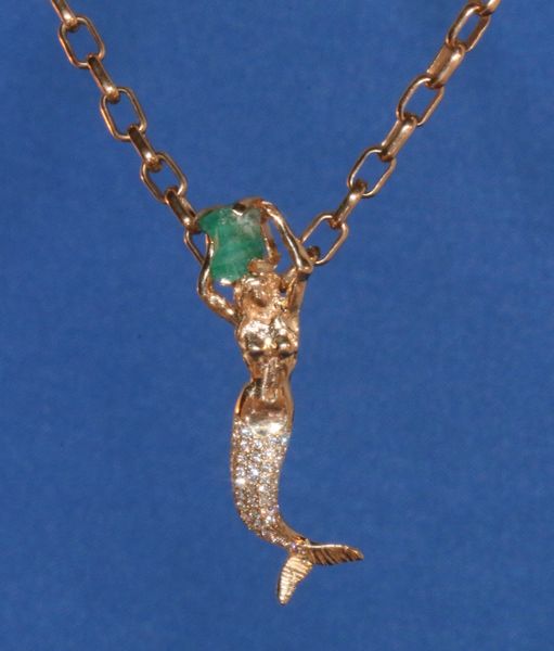 Mermaid in 14K Gold, holding raw 1K Emerald and Diamond covered tail