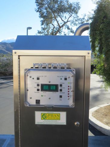 Outdoor industrial control panel with digital display in a sunny setting.