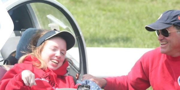 Volunteer and young person sitting in the glider before a flight.