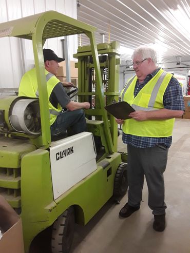 Industrial worker atop machine ensuring proper operation