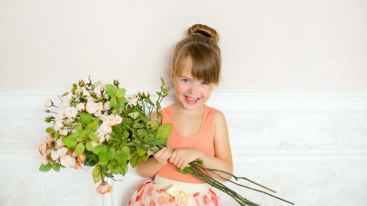 Young Girl Holding a Bouquet of Flowers