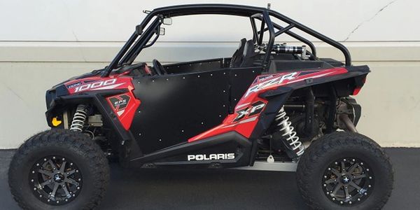Side view of a black and red Polaris off-road vehicle.