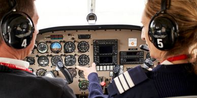 Dos pilotos en la cabina de un avión, observando los instrumentos.