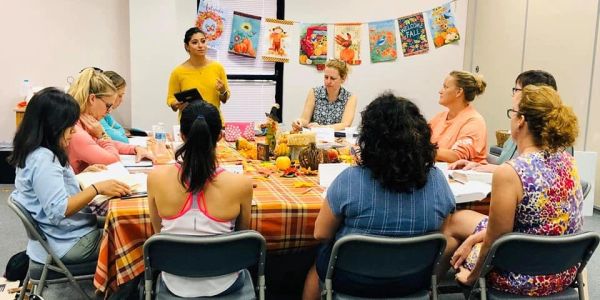 Group meeting around a table with fall decorations.