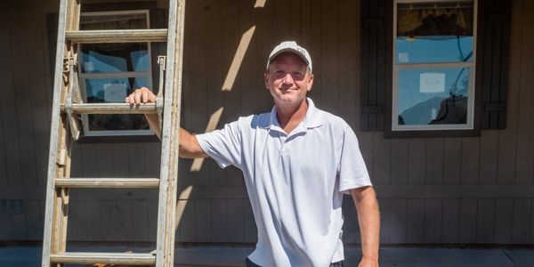 A man standing next to a ladder