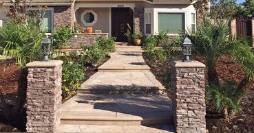 Stone steps leading up to front door and front garden landscape in Southern California
