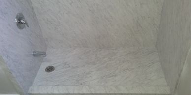 Gray quartz colour shower surround and marble walk-in shower floor for safe step-in shower.