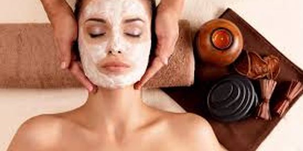 Woman receiving a facial treatment with a cream mask at a spa.