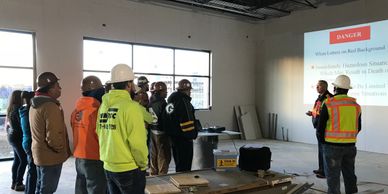 Construction workers attending a safety briefing inside a building under construction.
