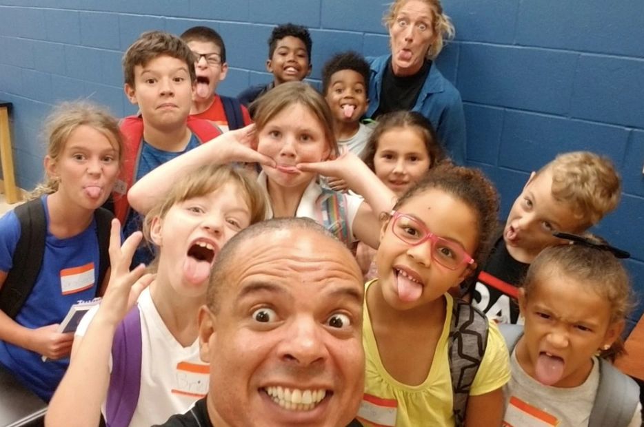 A selfie with an instructor in front and lots of students behind him, all making funny faces. 
