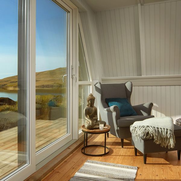 Cozy reading nook with armchair and lake view.