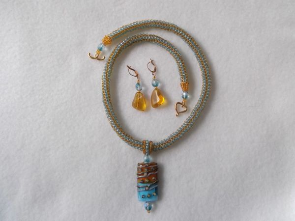 Tubular herringbone topaz and turquoise necklace with focal lamp-work pendant.