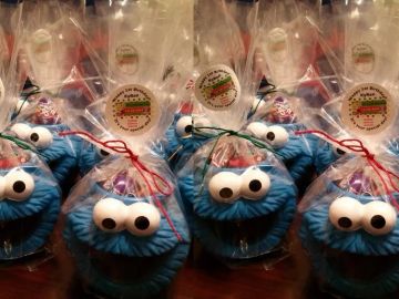 Cookie Monster-themed treat bags filled with goodies and tied with colorful ribbons.