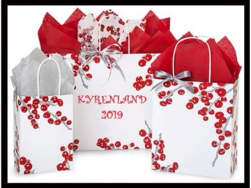 Three white gift bags with red cherry designs and red and white tissue paper.
