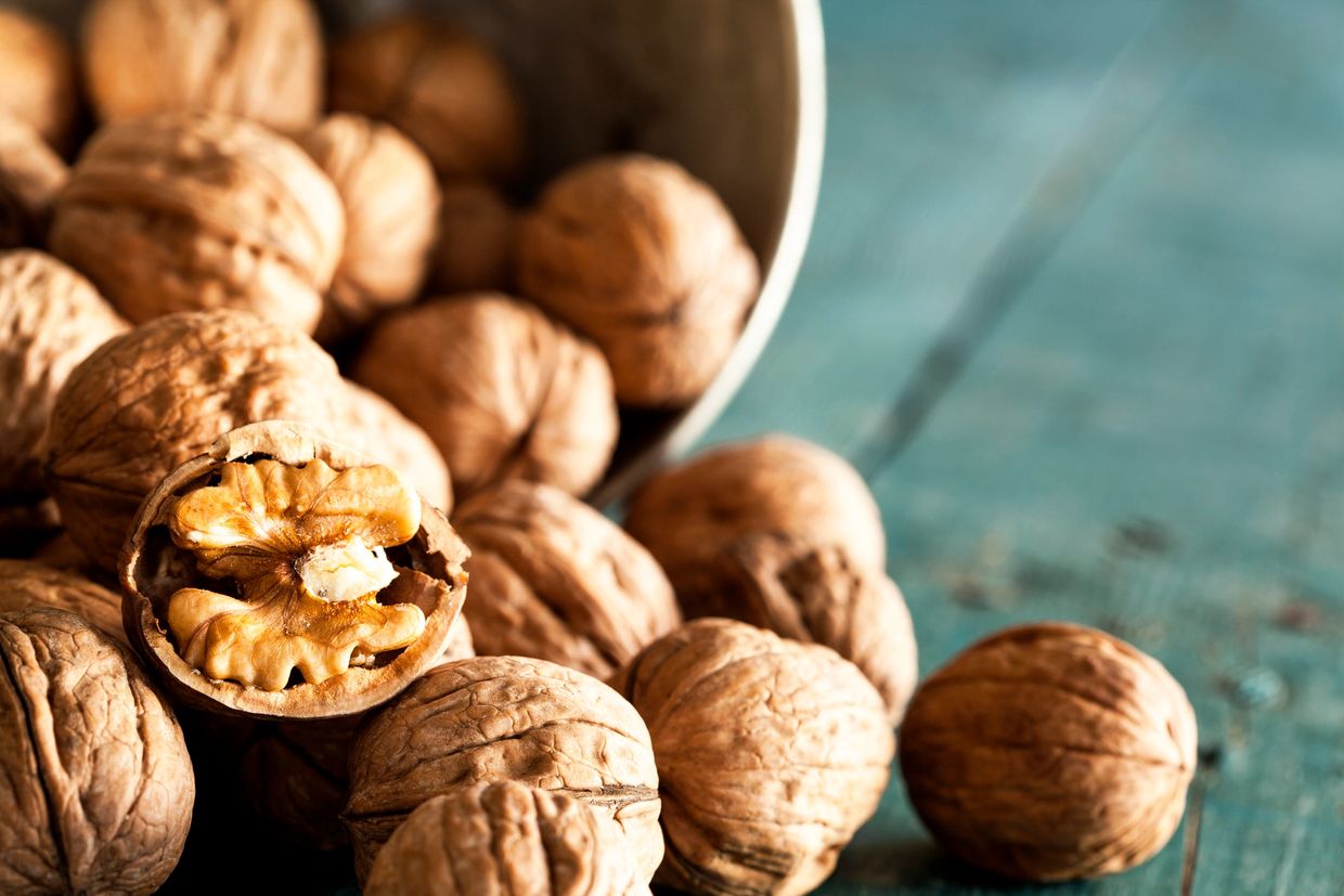 Whole and cracked walnuts spilling
