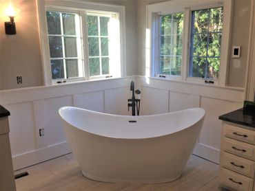 Bathroom renovations with new stand alone tub, wainscoting, new cabinets and tiled floor.