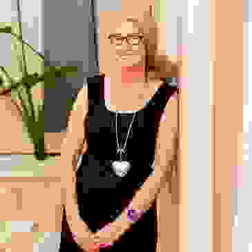 Felicity (Fliss) Wilson of Business Systems Sorted leaning on a wall, smiling.