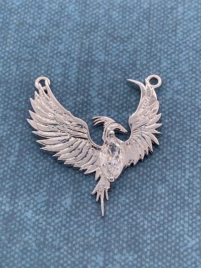 Exotic Phoenix emblem made from repurposed engagement ring and diamond.