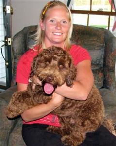 A woman holding a brown Australian labradoodle