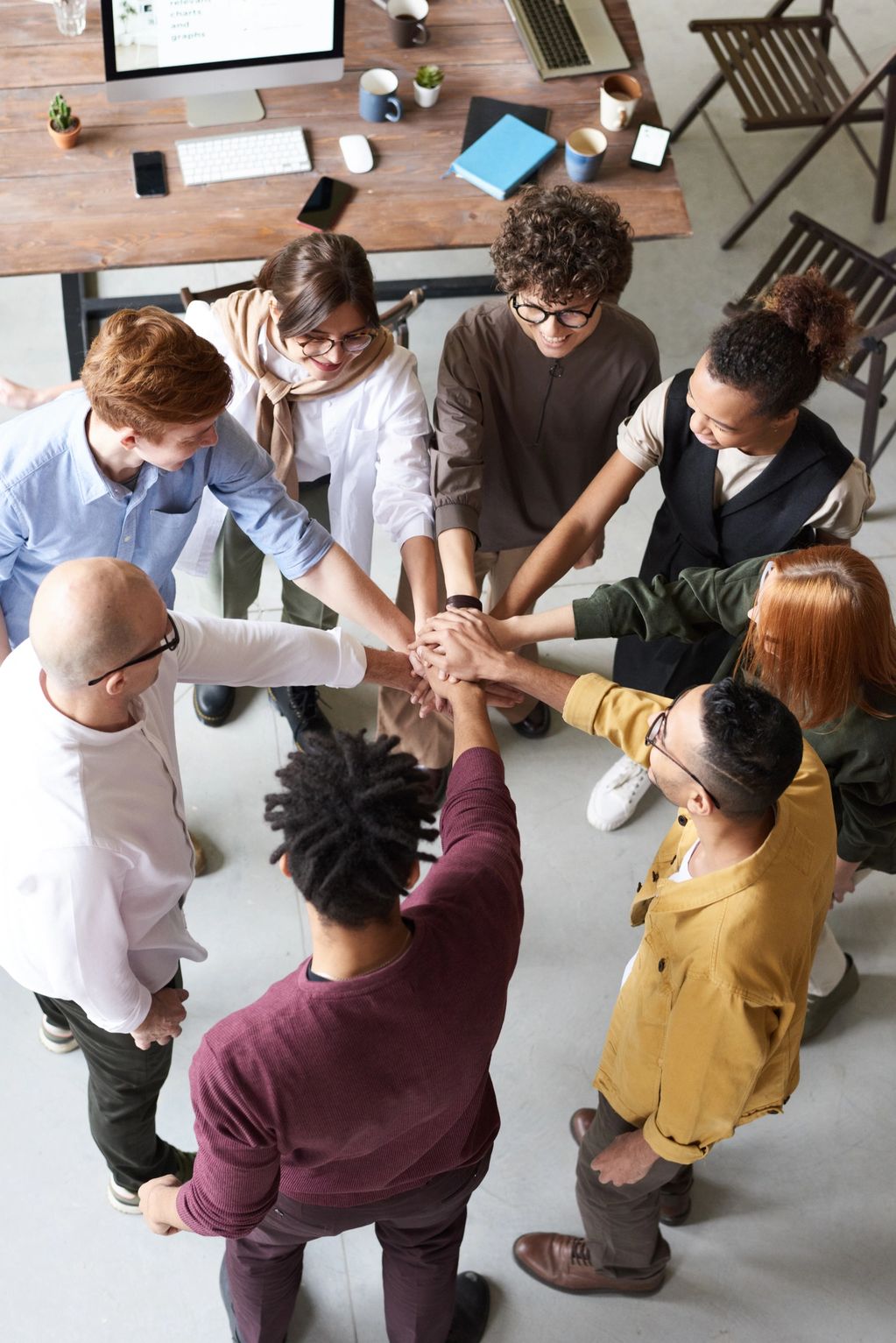 group of diverse young professionals bringing hands together for a huddle