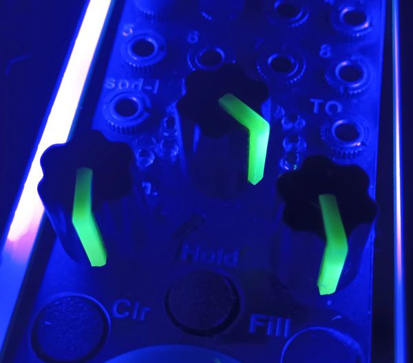 Black potentiometer knobs with a green light sensitive glow in the dark indicator.