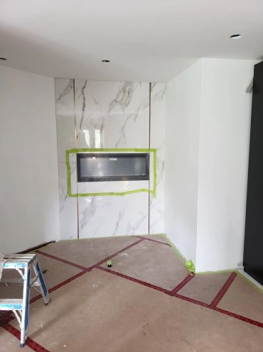 Cheminée encastrée en marbre dans une pièce en rénovation.