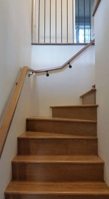Escalier en bois avec rampe inclinée irrégulièrement.