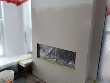 Mur fraîchement enduit avec ouverture protégée.