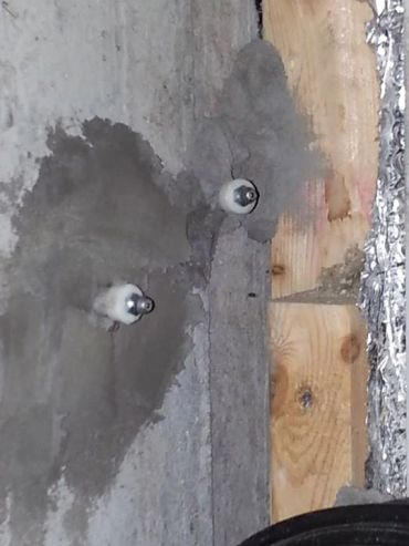 Deux ampoules fixées sur un mur en béton.