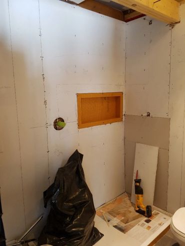 Salle de bain en rénovation avec murs préparés.