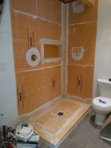 Salle de bain en rénovation avec douche en construction.