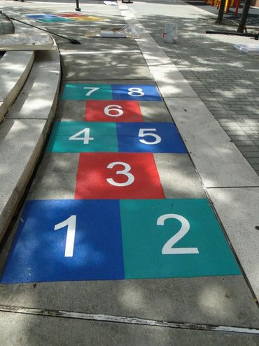 Preformed Thermoplastic Hopscotch, Numbered 1 to 8, on concrete in a playground by Surface Signs
