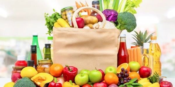 Grocery bag filled with fresh fruits and vegetables.