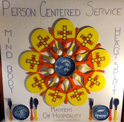 Decorative display of paddles and utensils highlighting person-centered service in hospitality.