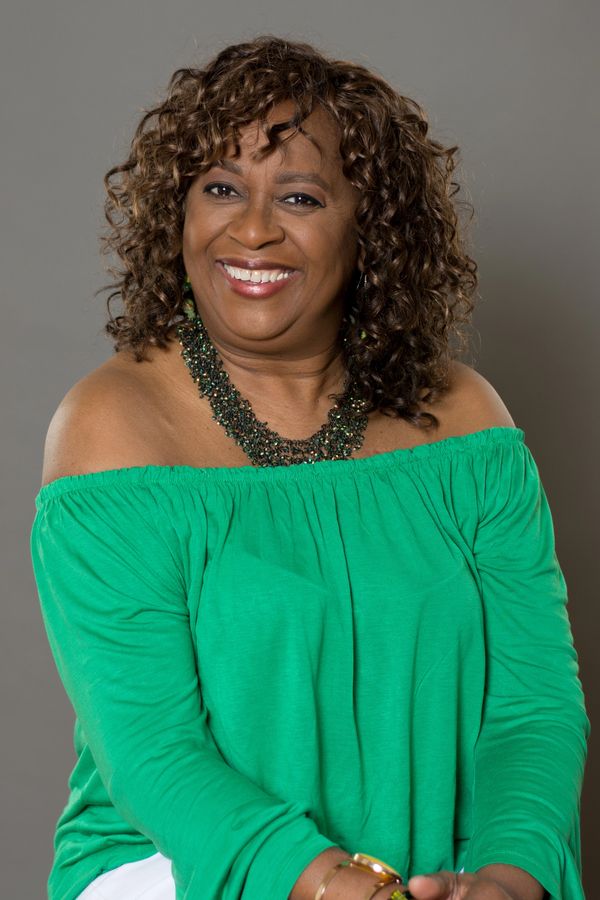 Woman smiling, green shirt, encouragement leader, sister