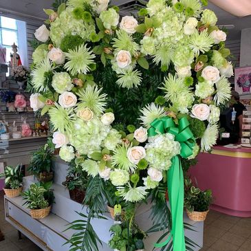 Heart-shaped floral arrangement with green and white flowers.