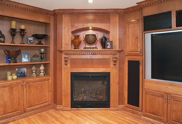 Entertainment Unit built from Mapel wood. brown in colour, has a TV and speakers 