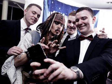Group of young men photographed while doing a selfie with Jack Sparrow look-a-like at a corporate event