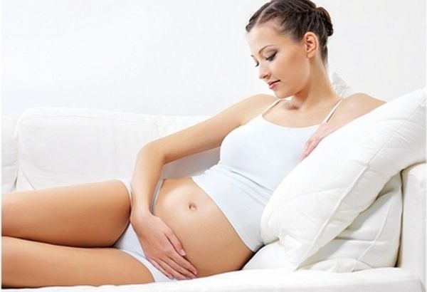 pregnant woman cradling her belly
