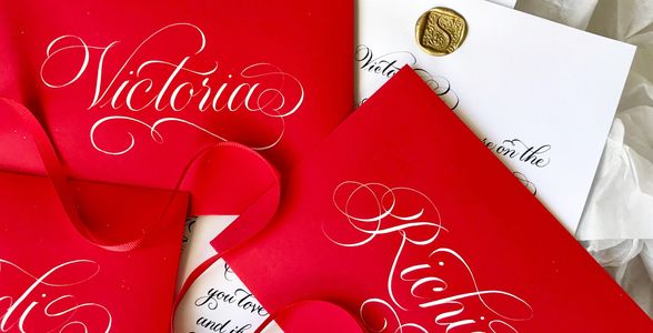 Elegant red envelopes with intricate white calligraphy on a white background.
