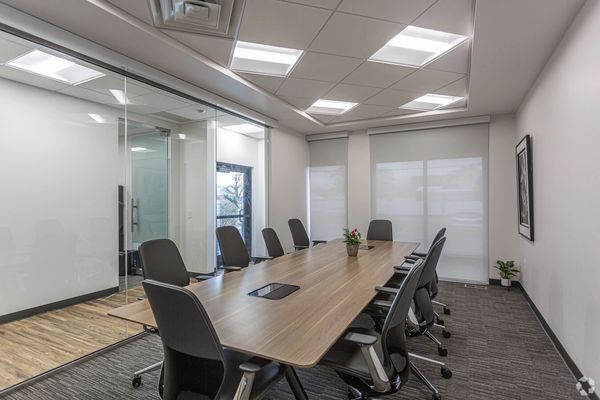 Conference room with 10 chairs and large wall of windows