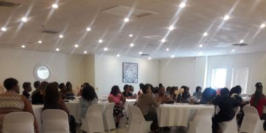 People seated at round tables in a conference room.