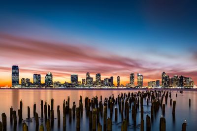 Skyline sunset view of Exchange Place Jersey City NJ, with remnants of Hudson River pier