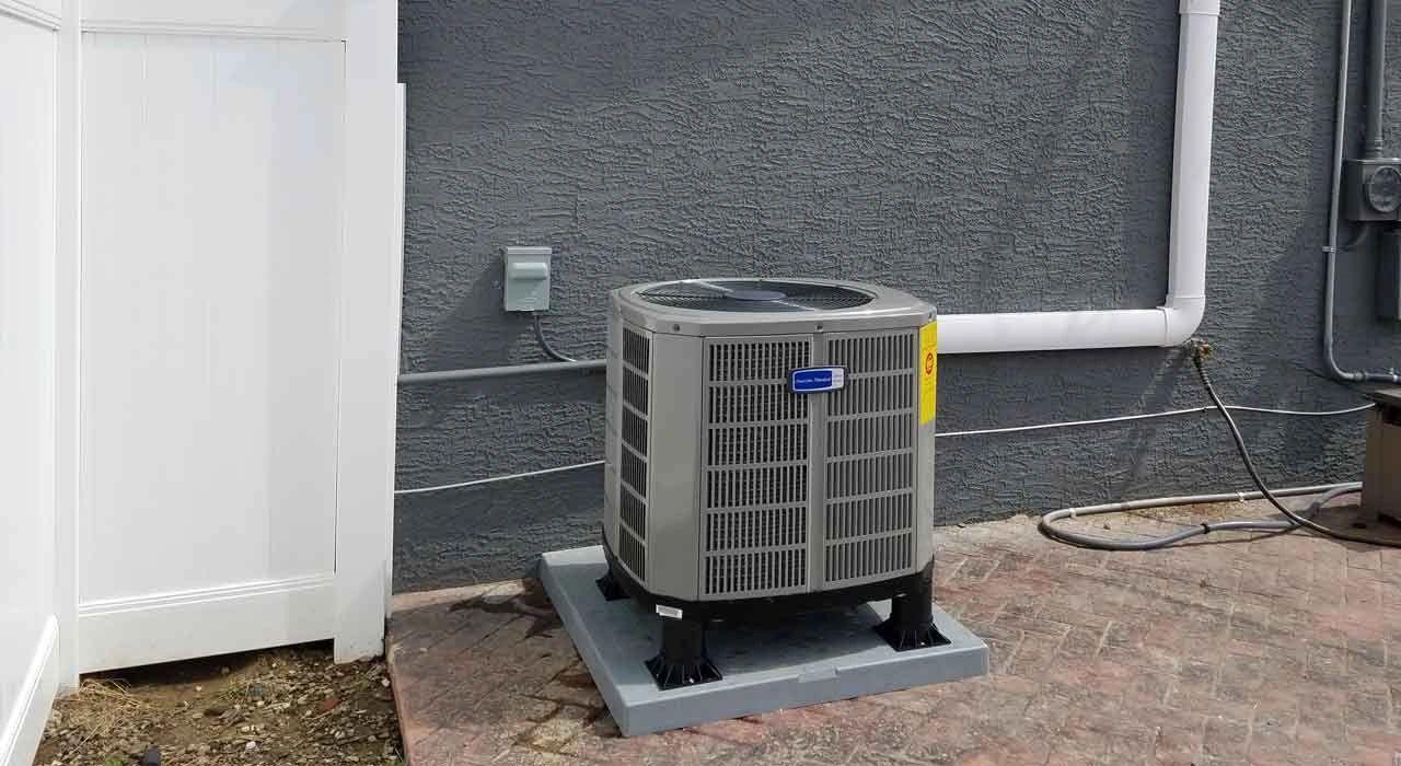 AC condenser on a pad outside the house